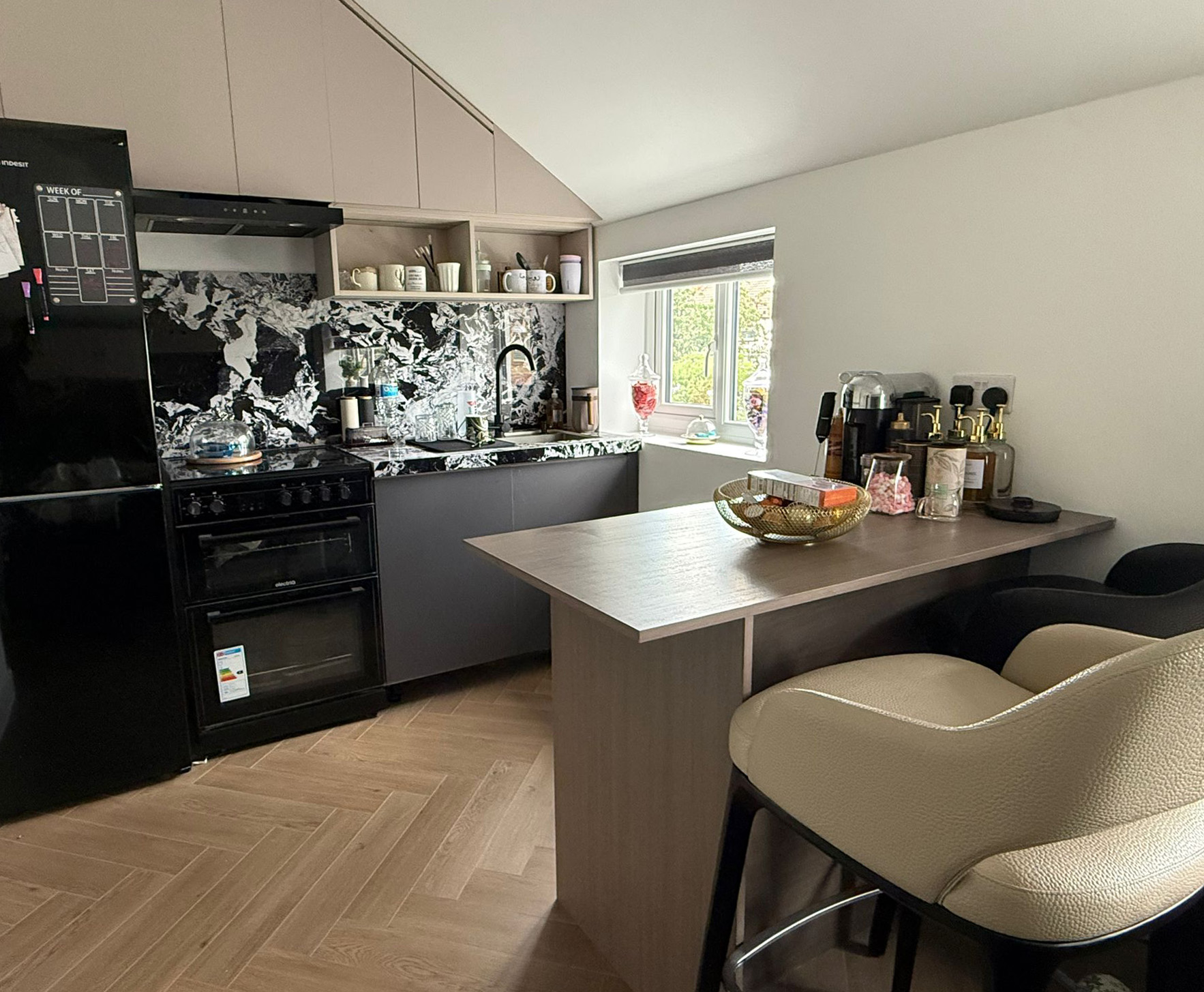 Mitcham kitchen completed — black marble splashback, dark cabinetry, herringbone floor