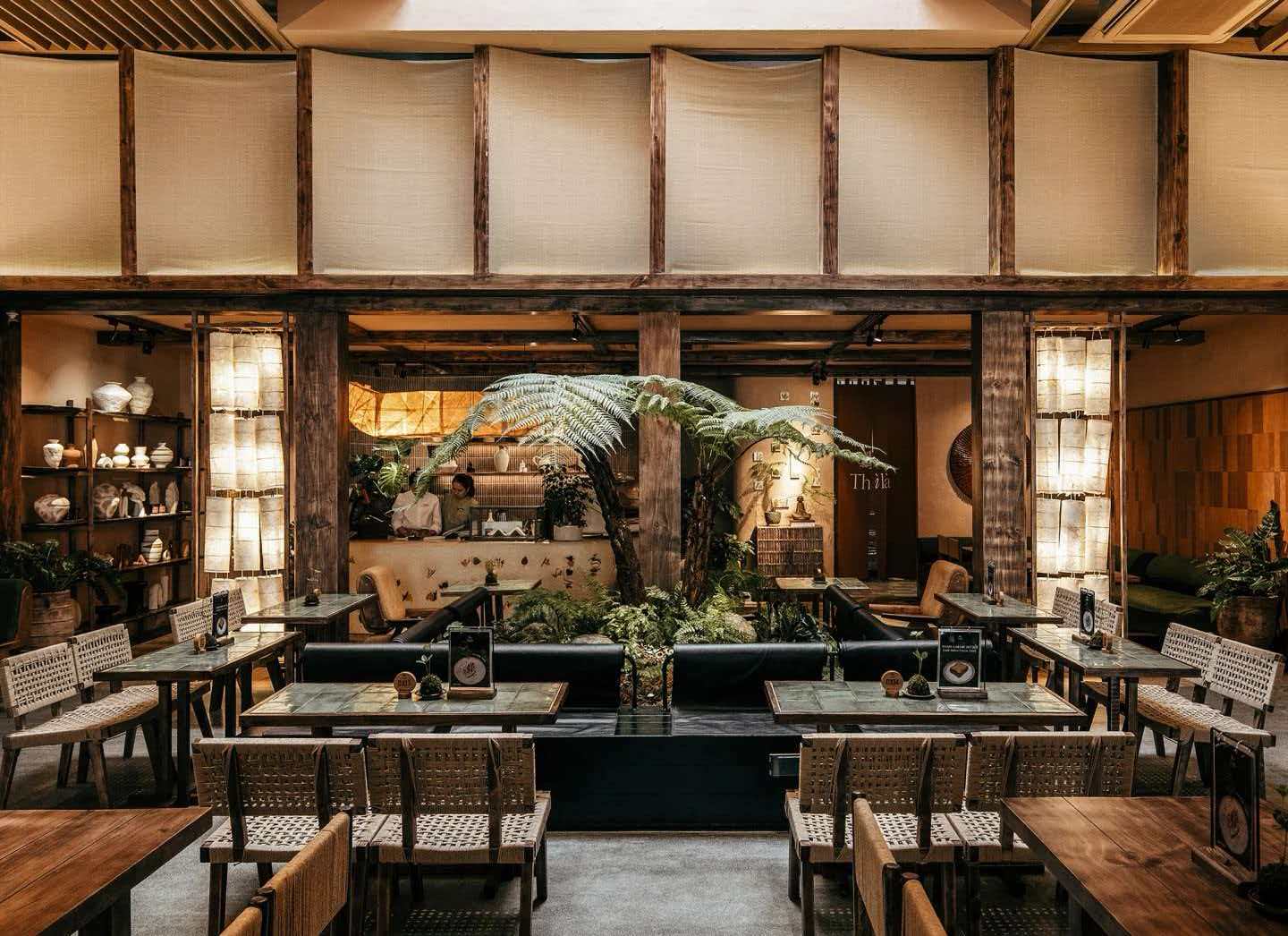 Biophilic restaurant with tree fern centrepiece and timber frame