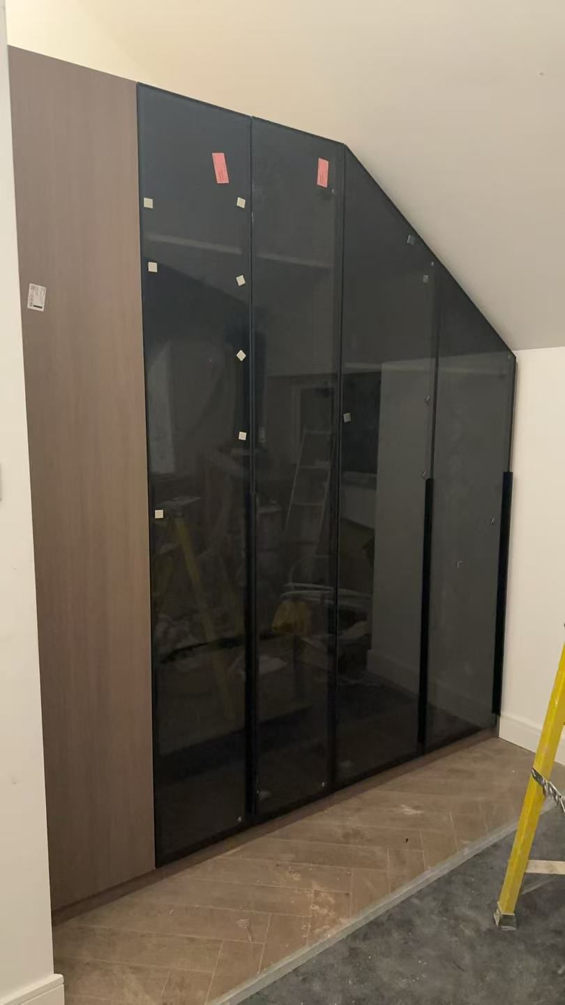 Wardrobe installed — glass doors fitted to angled ceiling space